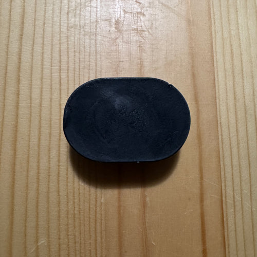 1 black oval soap on a wooden surface