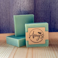 Three bars of green soap with a 'Amy's Handmade Soap' label on a wooden surface.