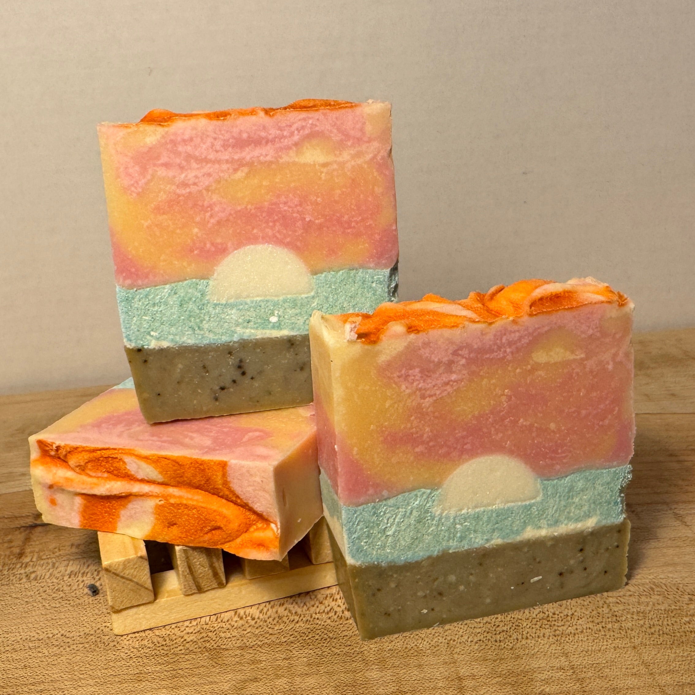 3 soap bars each that look like a beach, water and setting sun with sunset