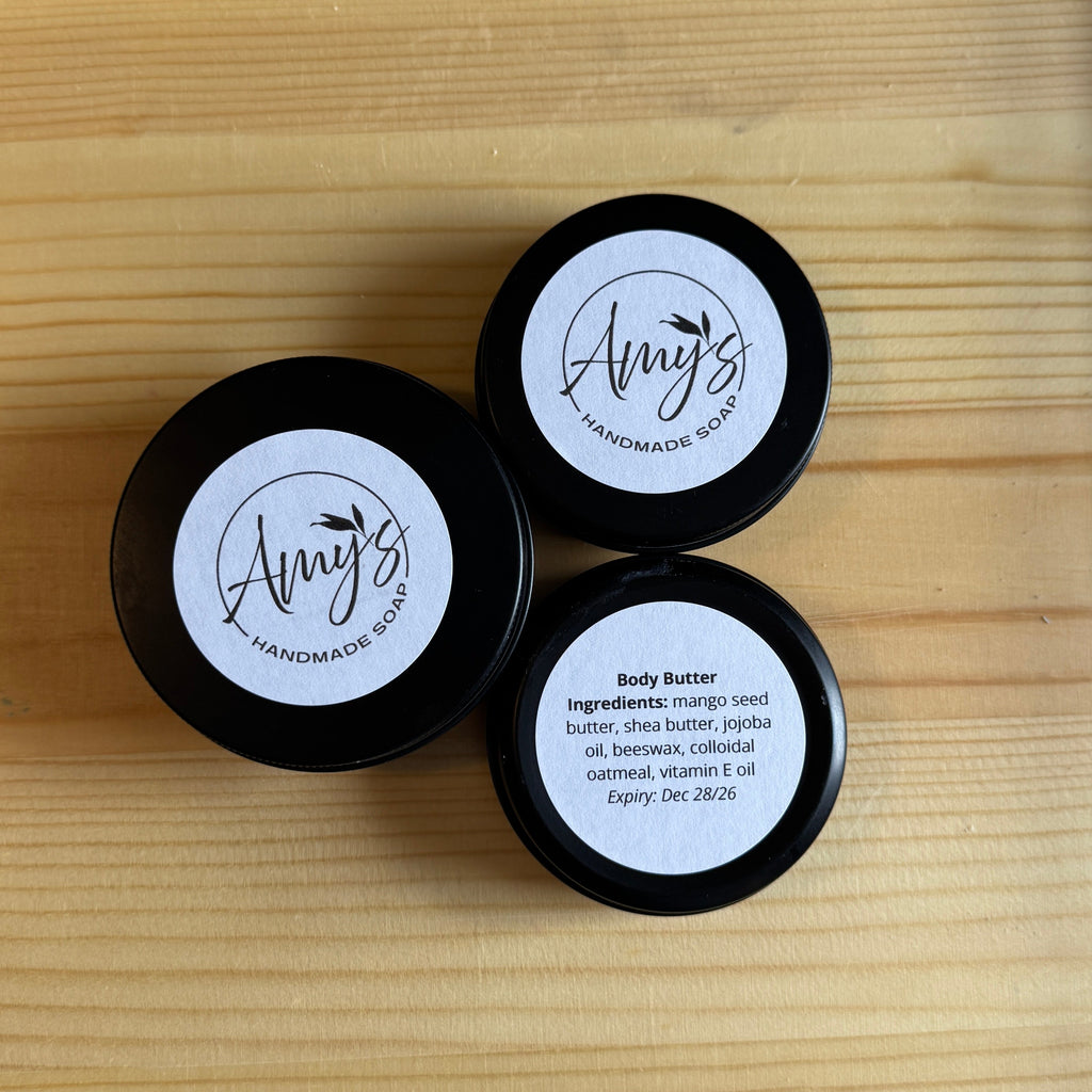Three black containers with 'Amy's' branding on a wooden surface.