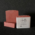 3 bars of red handmade soap on a black felt surface