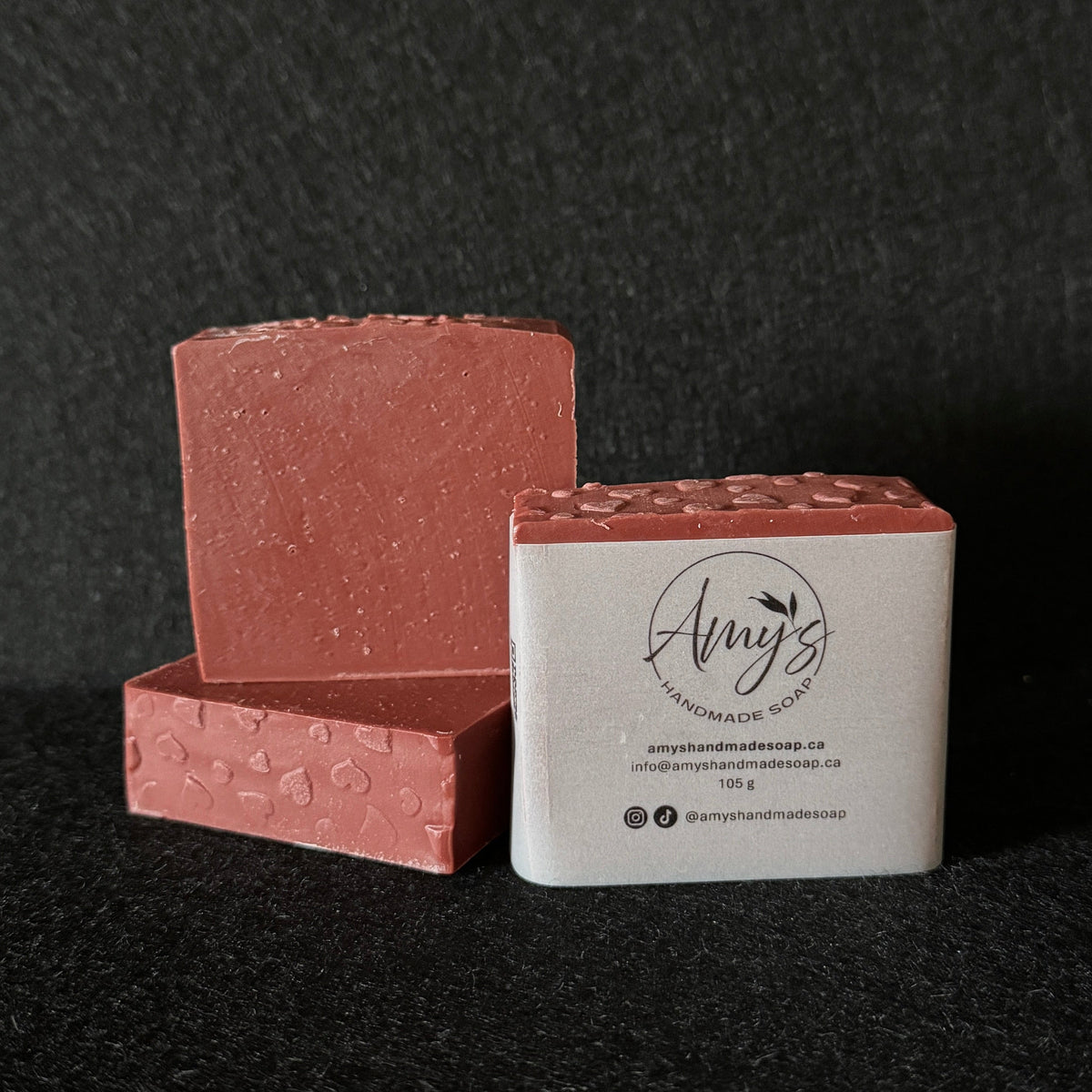 3 bars of red handmade soap on a black felt surface