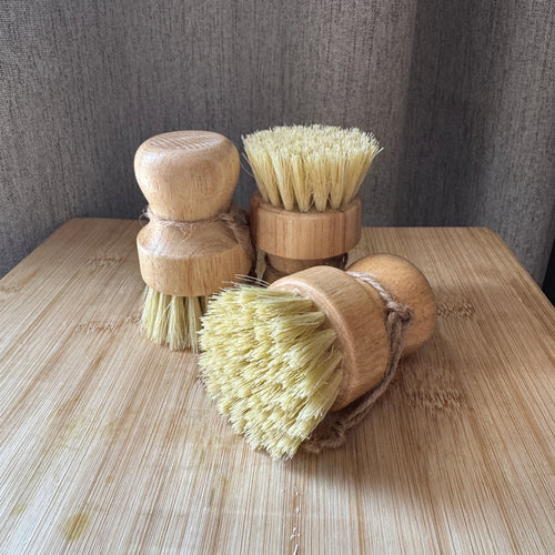 Set of wooden brushes with natural bristles on a wooden surface