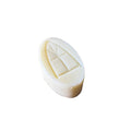 White soap bar with a unique design on a woven mat