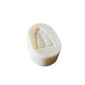 White soap bar with a design on a woven wooden surface