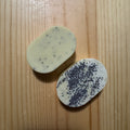 2 oval yellow soaps on a wooden surface