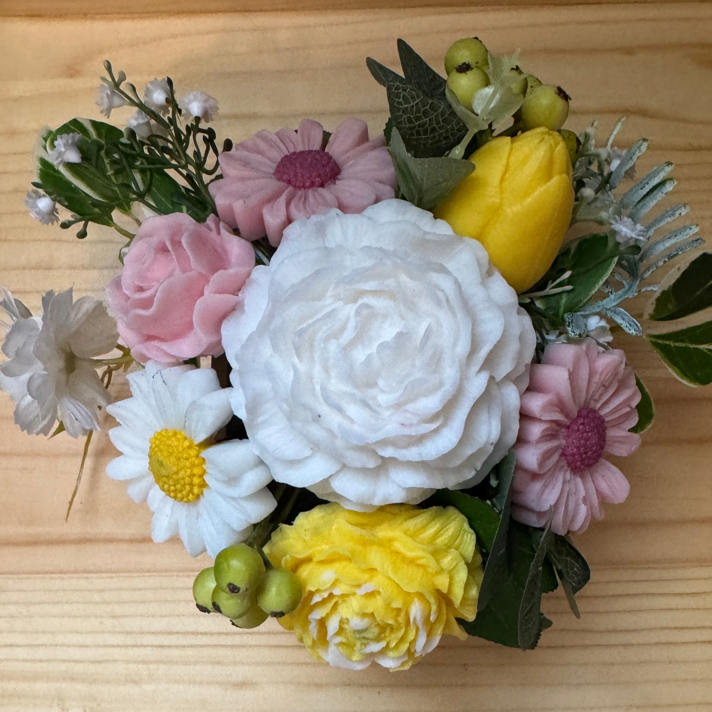 Bouquet of decorative flowers on a wooden surface