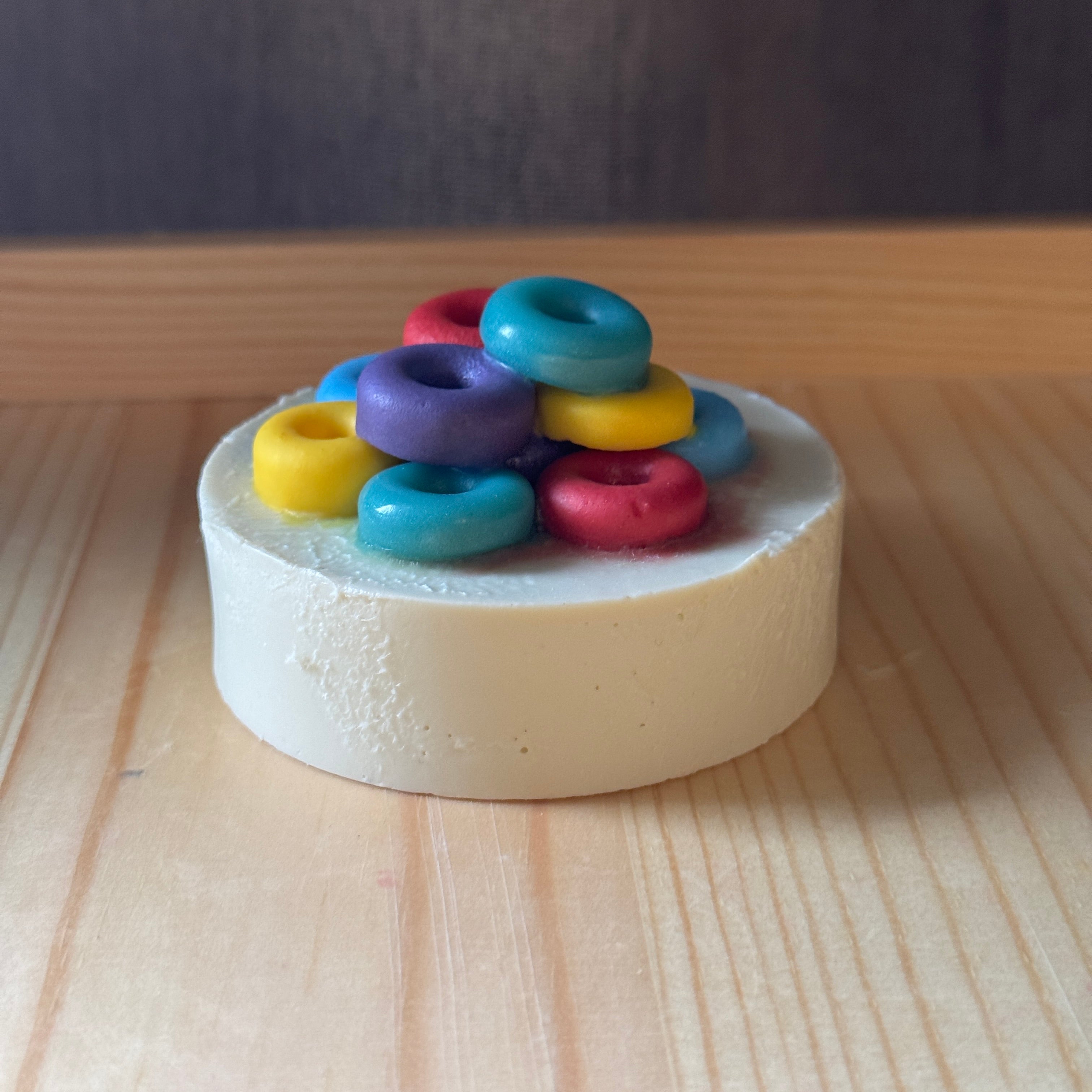 Colorful rings on a white soap base on a wooden surface