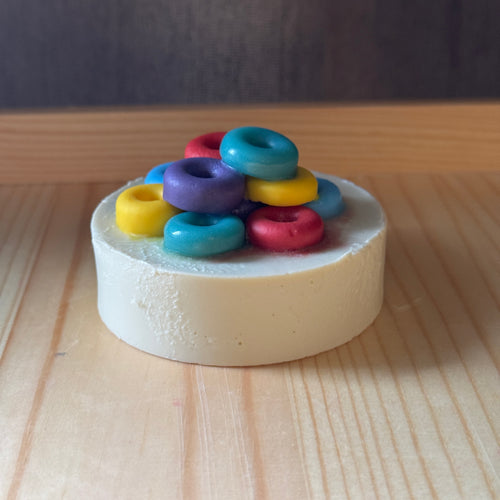 Colorful rings on a white soap base on a wooden surface