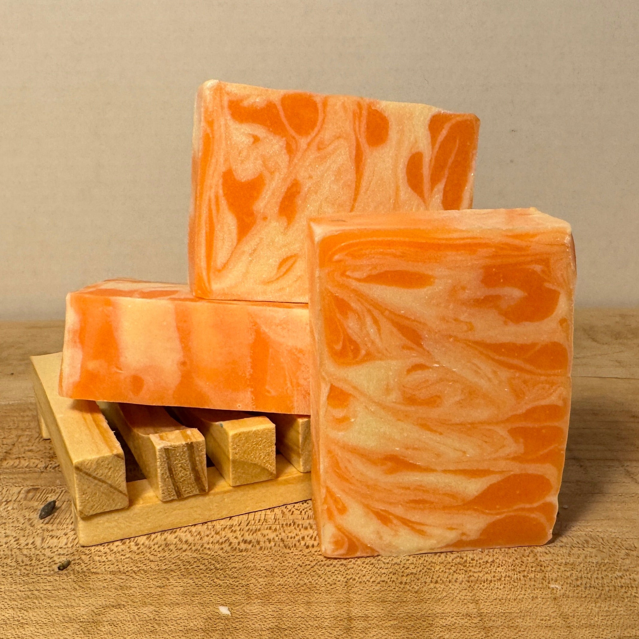 Orange and white marbled soap bars on a wooden surface