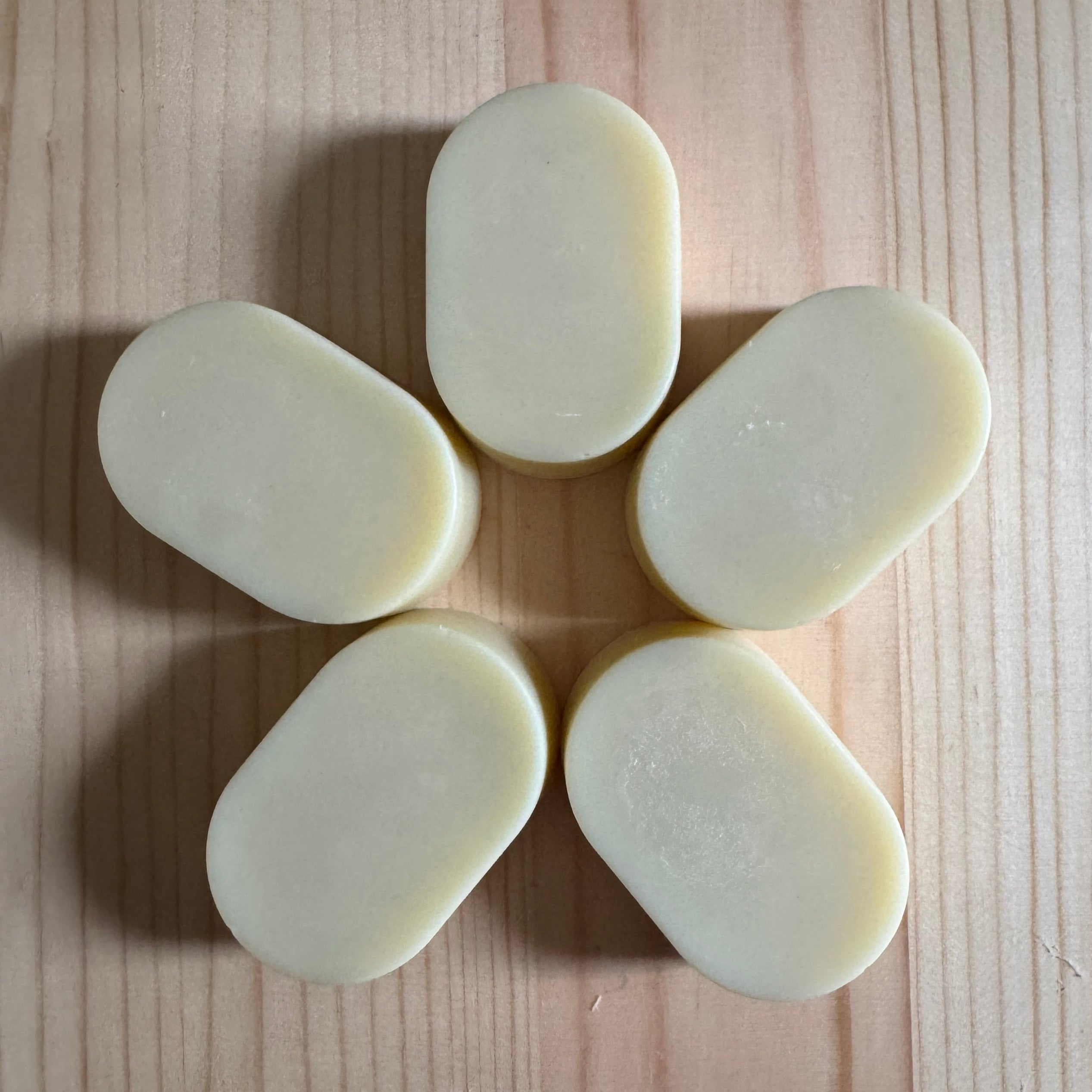 5 oval soaps on a wooden board