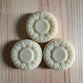 3 floral shaped soaps on a wooden board