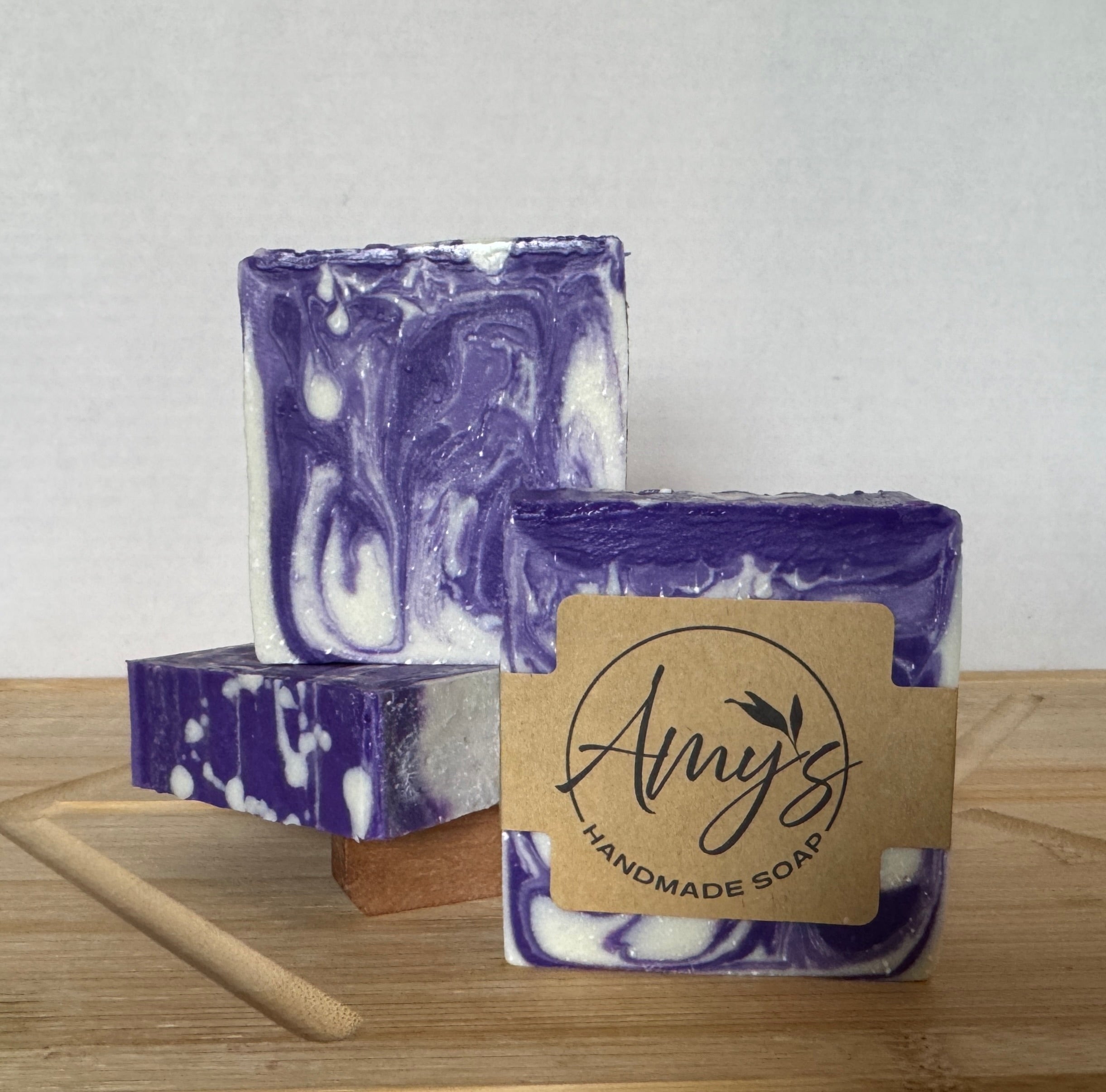 Purple and white marbled soap with a 'Amy's Handmade Soap' label on a wooden surface.