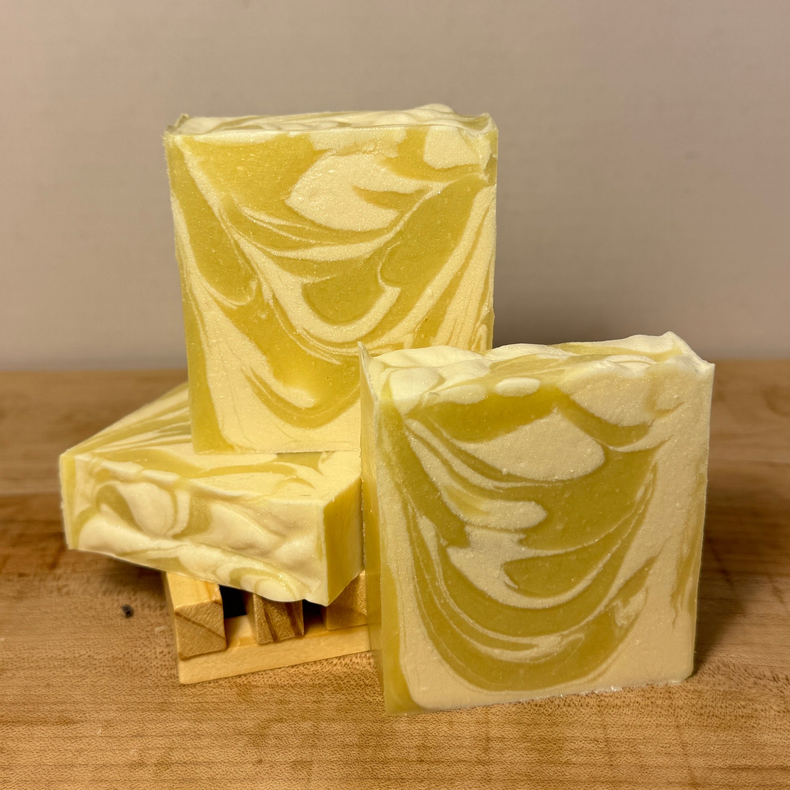 Three bars of soap with a marble pattern on a wooden surface