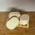 3 white oval bars of soap on a wooden surface