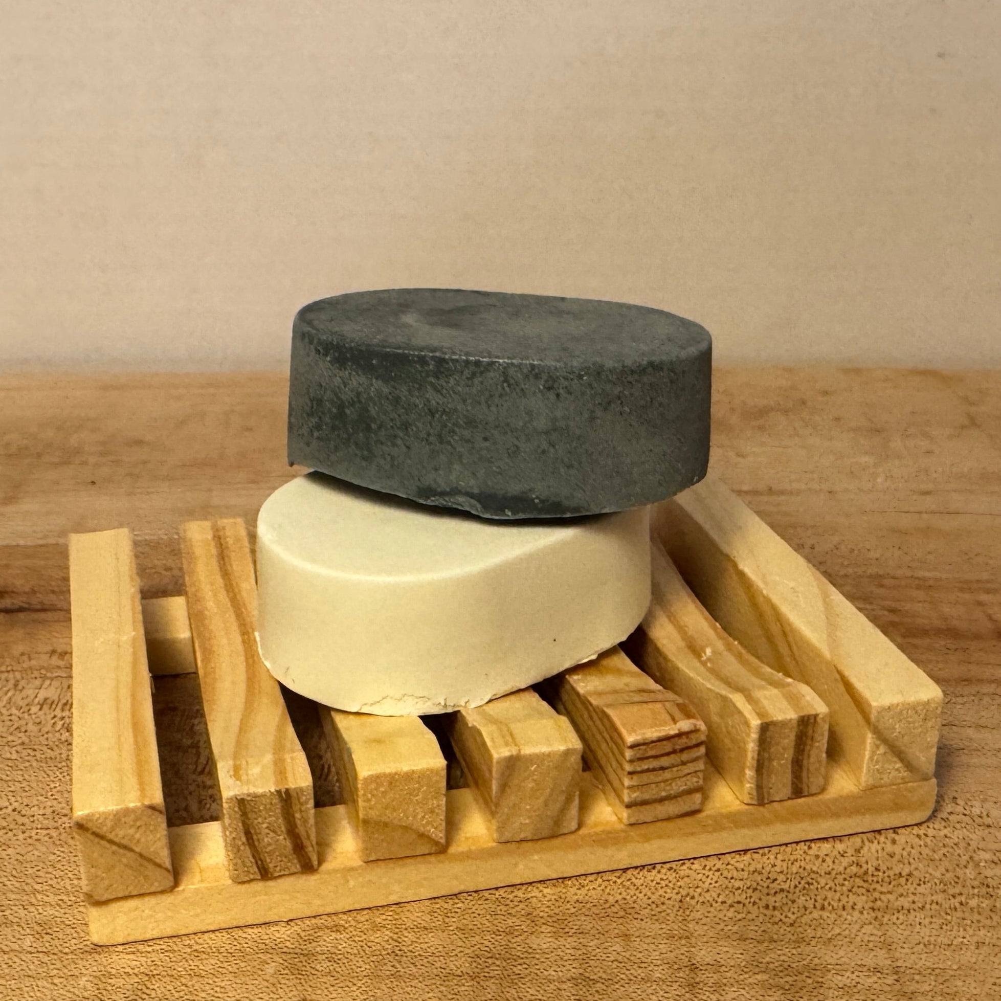 2 oval soaps on a wooden soap tray