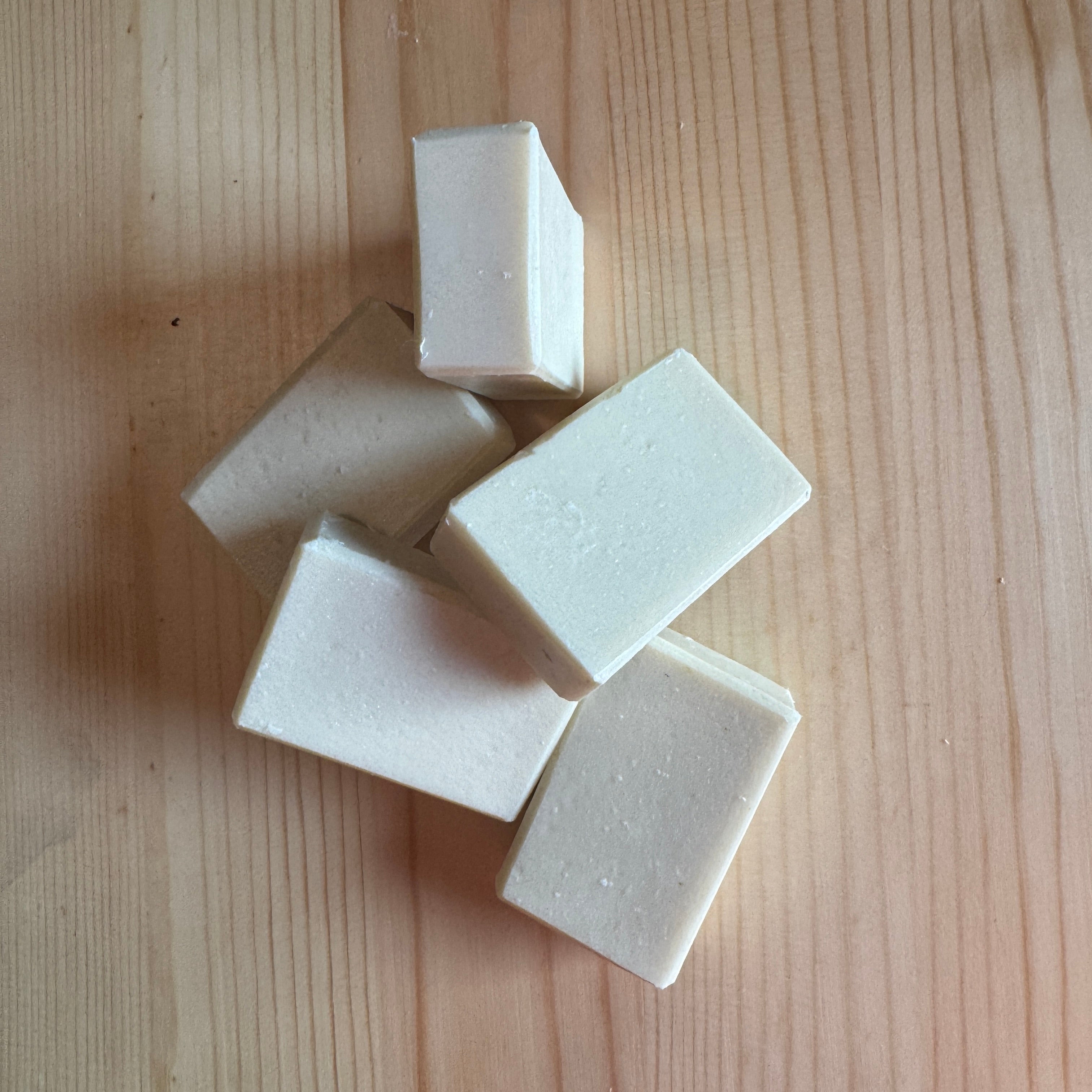 White soap bars on a wooden surface