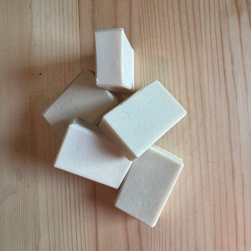 White soap bars on a wooden surface