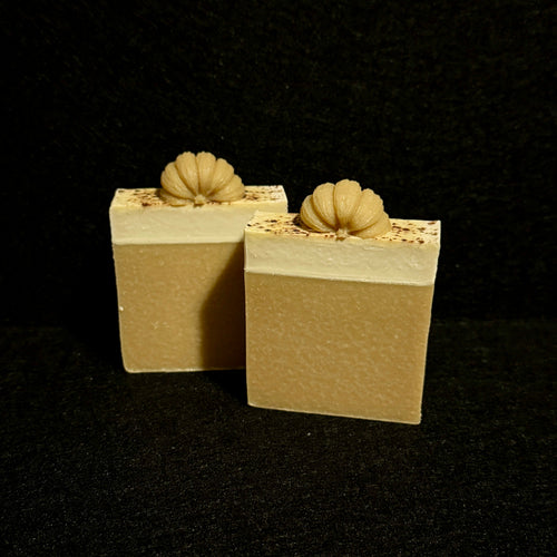 3 bars of handmade soap with orange yellow base and white top topped with a half pumkin
