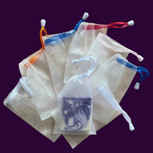 White drawstring bags with colorful tags on a wooden board