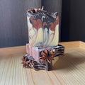 Marbled soap bar on a decorative stand with star anise on a wooden surface