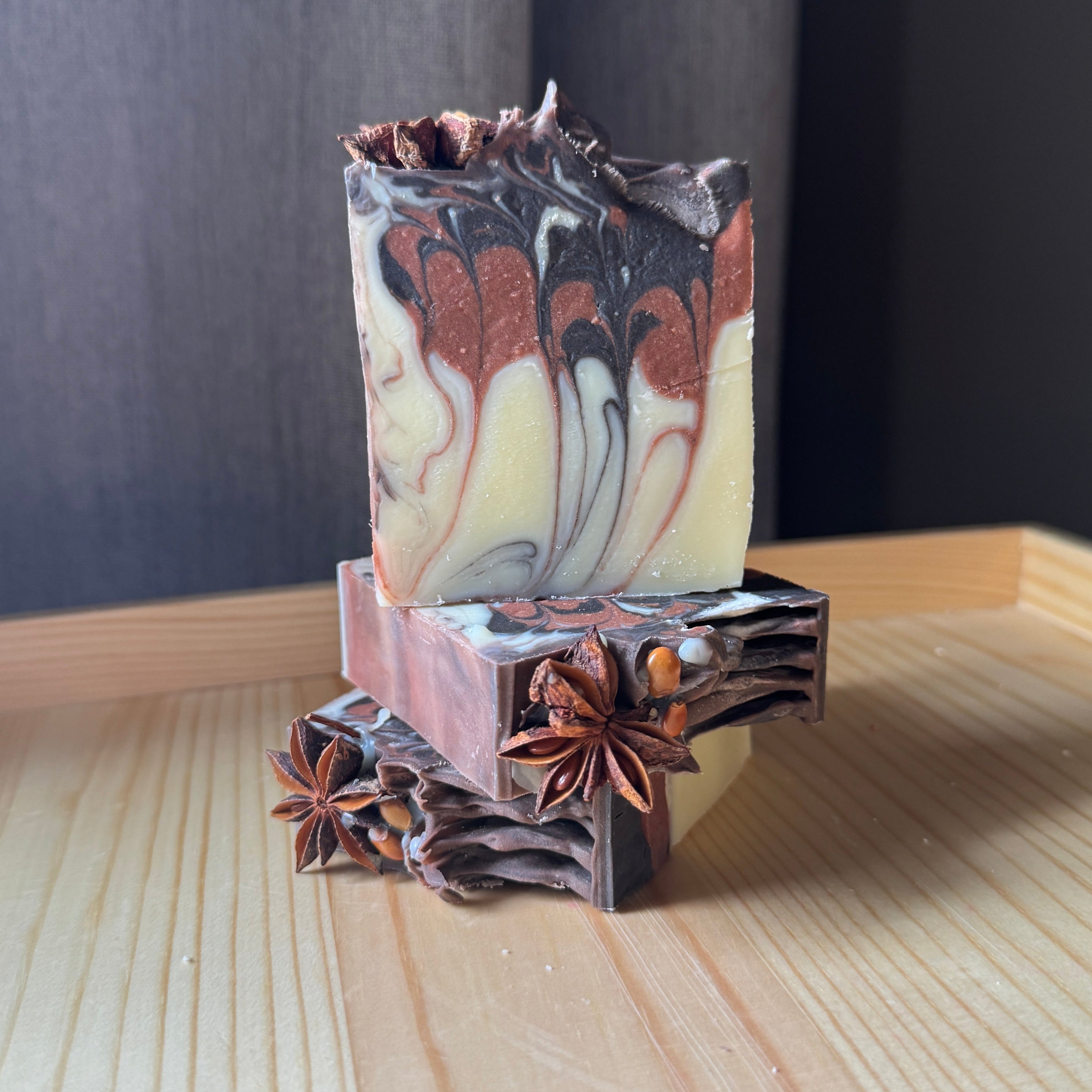Marbled soap bar on a decorative stand with star anise on a wooden surface