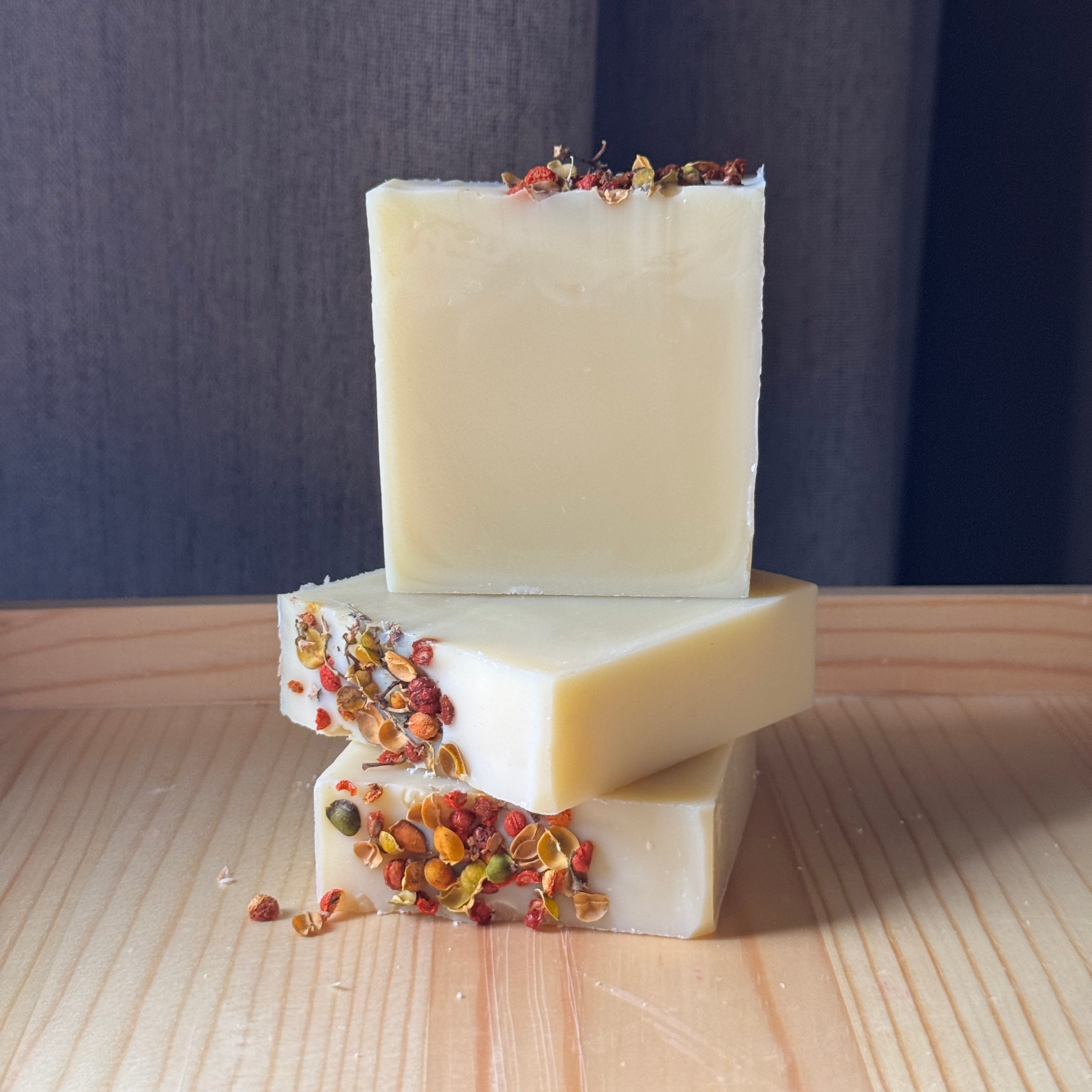 Two bars of soap with decorative elements on a wooden surface and dark background