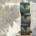 Three stacked soap bars with nature design in front of a waterfall