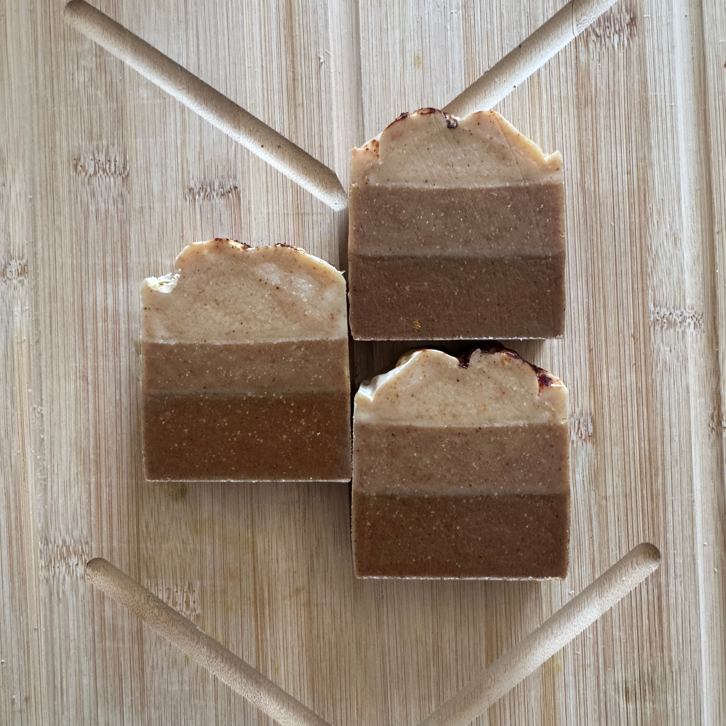 Three layered soap bars on a wooden background