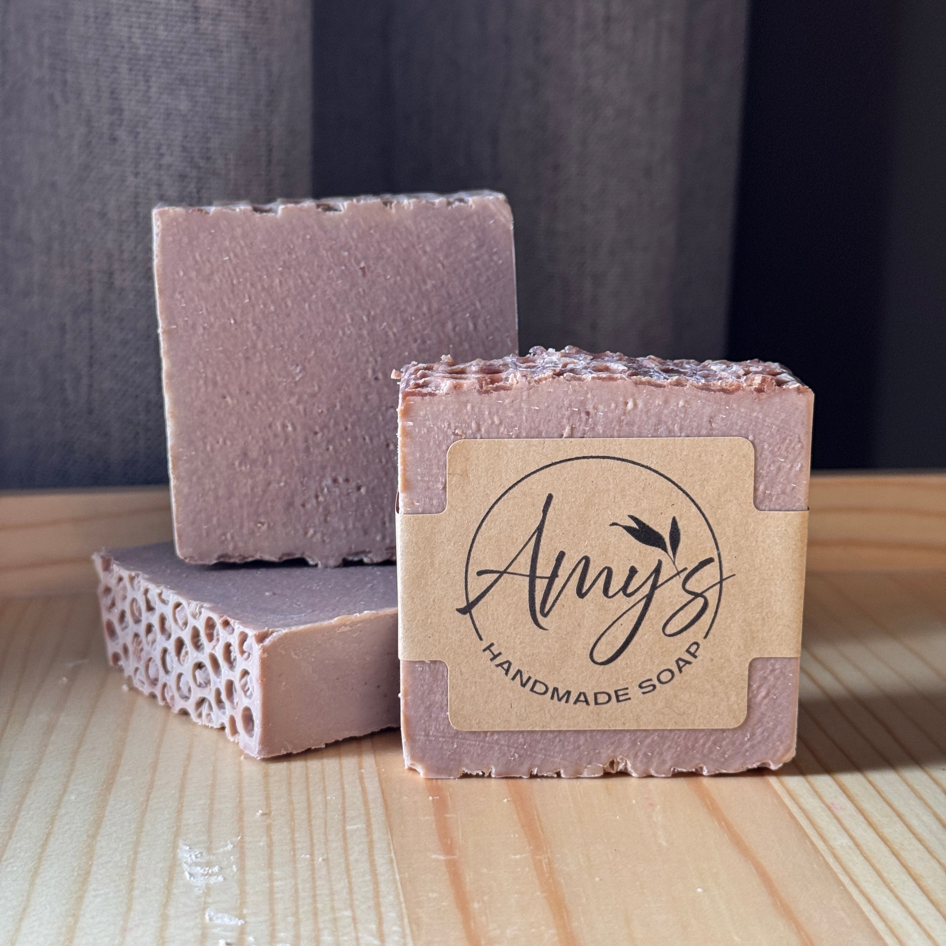 Handmade soap bars with 'Amy's Handmade Soap' label on a wooden surface.