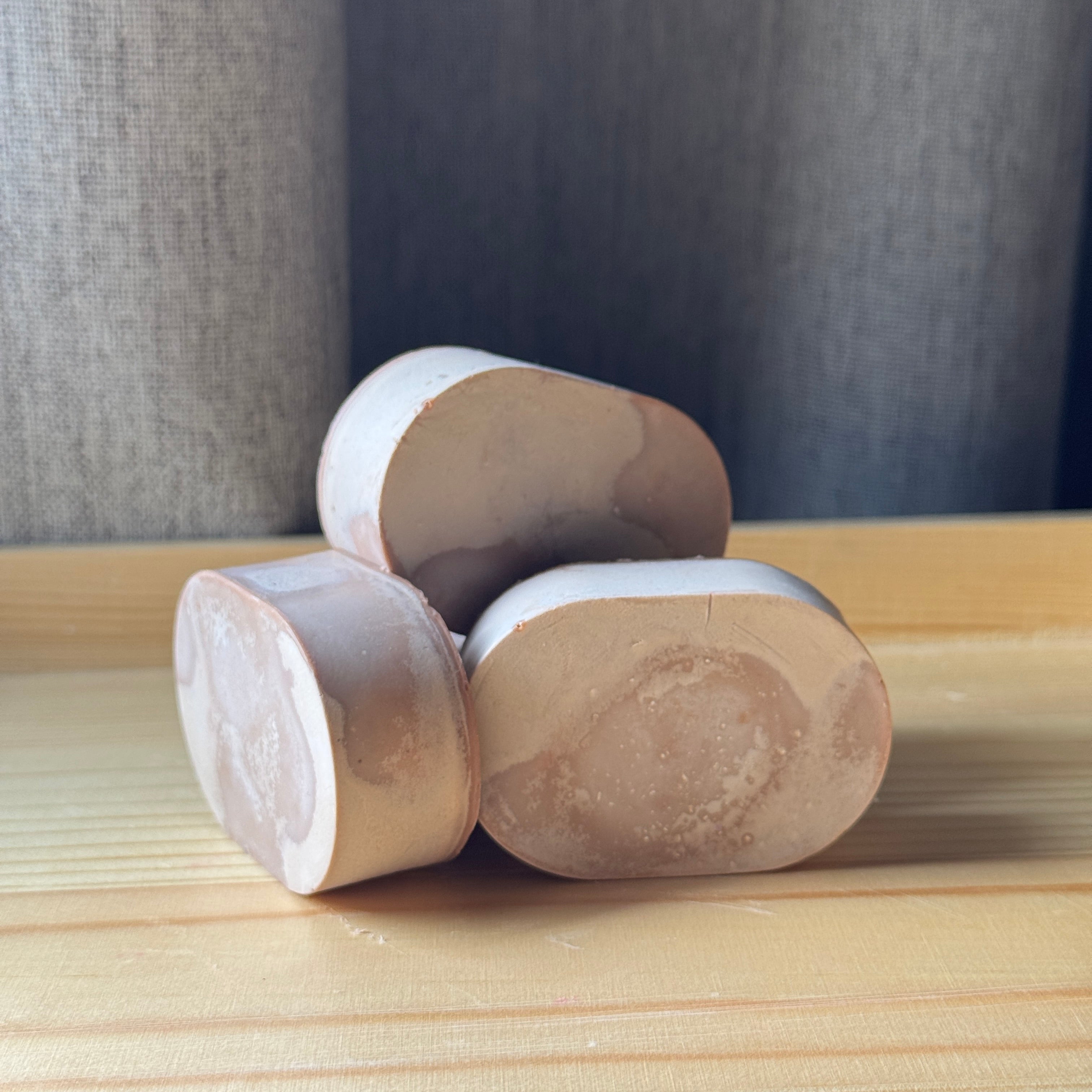 a set of oval shaped soaps on a wooden surface