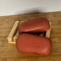 2 red bars of soap on a wooden surface
